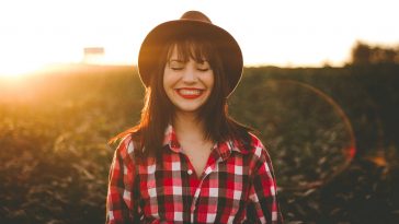 golden hour photography of woman in red and white checkered dress shirt