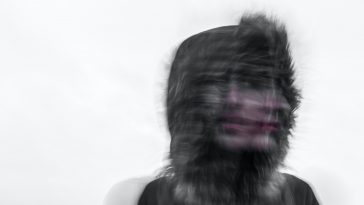 Creepy blurred photo of a person's face and a furry hood