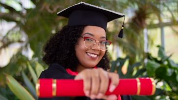 smiling woman wearing academic dress and black academic hat