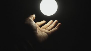 a hand holding a light in the dark