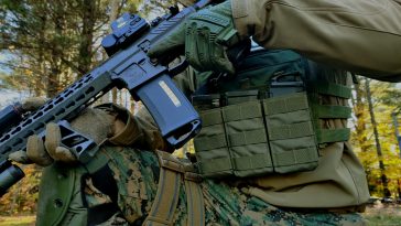 man in green and brown camouflage uniform holding black rifle