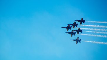 six black fighter jets doing air show during daytime