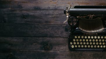 black Corona typewriter on brown wood planks